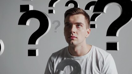 Aufkleber - Multiple views of a thoughtful young man pondering numerous floating question marks against a seamless gray backdrop, symbolizing decision making and problem solving