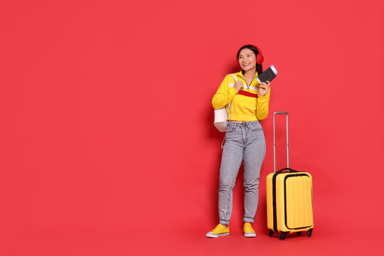 Wall Mural -  - happy traveller with passport and suitcase on red background. space for text