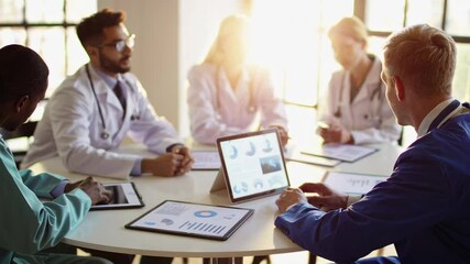 Aufkleber - Healthcare professionals gather around a table, engaging in a discussion and analyzing medical data on tablets and documents in slow motion
