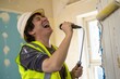 © IbragimovN - Joyful construction worker singing with microphone in renovation setting