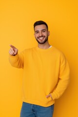 Sticker - A man in a yellow sweater is pointing to the camera with a smile on his face. Concept of positivity and friendliness