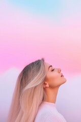 Wall Mural - A woman with long blonde hair is looking up at the sky. The sky is pink and purple, and the woman is wearing a white shirt