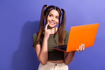 Wall Mural - Happy young woman holding colorful laptop and thinking against vibrant background