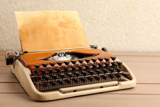 Vintage typewriter with parchment paper on wooden table