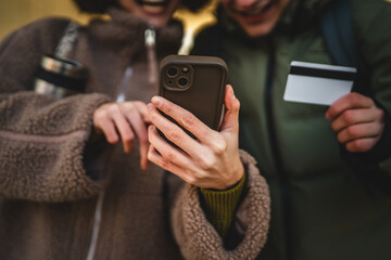 close up on male and female hands hold mobile phone and credit card