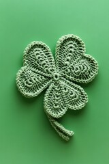 Wall Mural - A green crochet flower with four hearts. The flower is a symbol of luck and good fortune. The green color of the flower and the green background create a sense of harmony and positivity