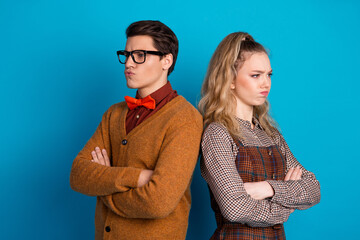 Canvas Print - Young couple posing with crossed arms against a blue background, displaying humor and retro fashion in a casual style