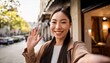 © ochikosan - 笑顔で手を振っているビデオ通話中の女性。（Woman on video call smiling and waving.）