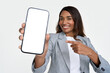 © insta_photos - Happy African American young business woman holding smartphone in hands pointing at big mockup phone screen showing cellphone advertising new financial mobile phone app isolated on white background.