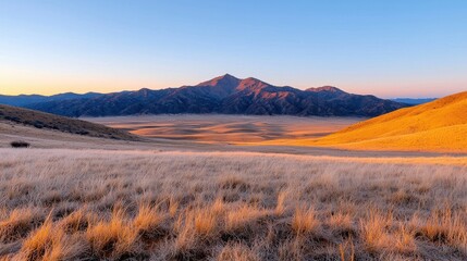 Wall Mural - Sunset over mountain valley, golden grass foreground, travel poster