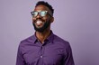 © Vadym - Happy African American man wearing eyeglasses, purple shirt. Studio shot. Positive expression. Confident pose. Stylish man. Great for business fashion. Excellent choice for portfolio. Modern look.