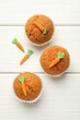 © New Africa - Tasty carrot muffins on white wooden table, flat lay