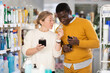 © JackF - Couple adult man and woman buyers testing perfume in household chemicals store