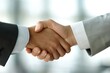 © Emily - Confident businessman greeting a colleague with a firm handshake in a professional office setting. Corporate teamwork, leadership, and successful business negotiations.