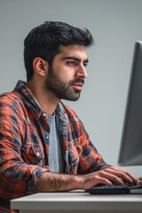 Poster - A person sitting at a desk with a computer and possibly doing work or research