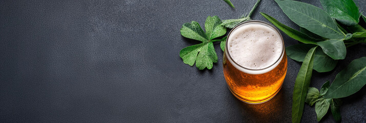 Wall Mural - Glass of light beer with green leaves on dark background. Refreshment and relaxation concept. For menu, advertising, banner, poster. Top view with copy space.