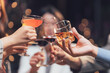 © Kritdanai - Cheers to Good Times: A close-up shot captures hands raising glasses of various alcoholic beverages, symbolizing camaraderie, celebration, and shared joy.