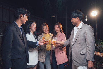 Nighttime Cheers: Friends raise their glasses in a celebratory toast under the warm glow of night lighting.  A vibrant group enjoys a moment of togetherness and camaraderie.