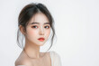 © kazakova0684 - A beauty portrait of a young Asian woman gazing thoughtfully, her soft hair framing her face, dressed in light-colored attire on a pure white background