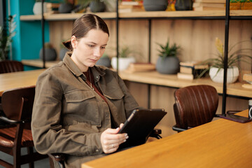 A beautiful and elegant girl works online in a cafe.