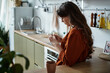 © LIGHTFIELD STUDIOS - Woman reflecting in a serene kitchen space while managing emotional struggles