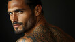 © godex - Intriguing Gaze: A close-up portrait of a handsome man with dark hair, intense eyes, and a neatly trimmed beard, featuring a captivating tattoo. His gaze draws you in.