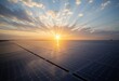 © ILIUSIA - Expansive solar farm illuminated by the warm glow of the setting sun with vast rows of solar panels extending to the horizon and power lines in the background