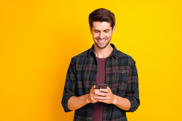 Aufkleber - Photo of blogger guy holding telephone in hands checking subscribers wear casual checkered shirt isolated yellow color background