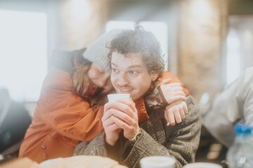 Poster - A couple sits in a warm café during winter, enjoying coffee and sharing joyful companionship.