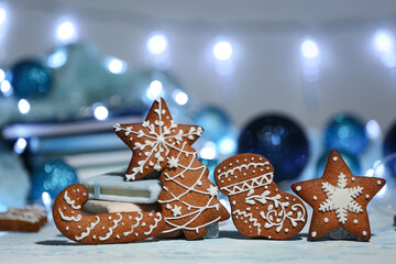 Wall Mural - Christmas gingerbread cookies and balls on table against blurred lights