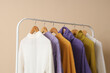 © Pixel-Shot - Rack of stylish clothes near beige wall, closeup