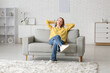 © Pixel-Shot - Young happy woman resting on sofa in living room