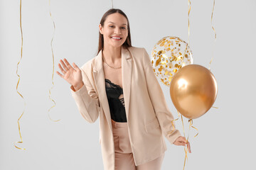 Wall Mural - Happy young woman with air balloons on grey background