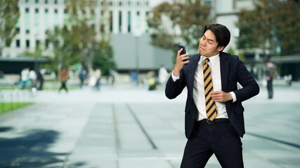 Leinwandbilder - 街でスマホを見ながらダンスする男性ビジネスパーソン