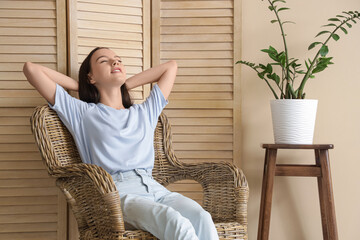 Wall Mural - Teenage girl resting in wicker armchair at home