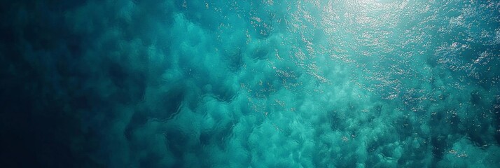 Poster - Aerial view of calm ocean water surface with sun reflecting and creating beautiful turquoise patterns, ideal for summer and travel themes, showcasing the beauty of nature and tropical destinations