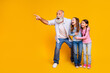 © deagreez - Grandfather Enjoying Bonding Time with Excited Grandchildren on Vibrant Yellow Background