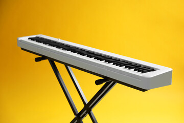 Wall Mural - Synthesizer on yellow background, closeup. Electronic musical instrument