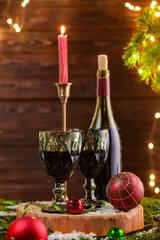 Canvas Print - Red wine and beautiful Christmas decor on wooden table against blurred festive lights