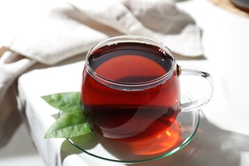 Wall Mural - Refreshing black tea in cup on light table, closeup