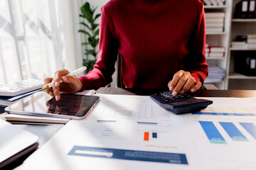 Wall Mural - Business financing accounting banking concept. Business woman hand doing finances and calculate on desk about cost at home office. Woman working on desk with using calculator, finance accounting.
