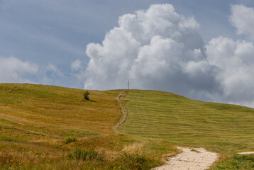 autumn landscape at pralongia plateau, northern italy, featuring a winding path through a grassy hil