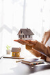 © David - Hand of woman holding model house, real estate mortgage insurance and mortgage loan property insurance dream banking concept.