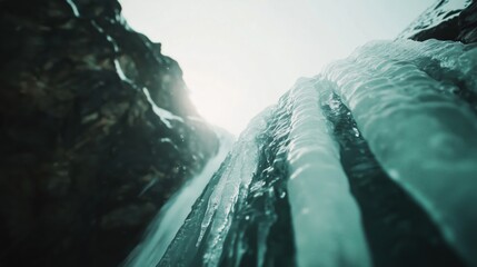 Wall Mural - A close-up view of an ice waterfall cascading down rocky cliffs.