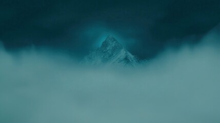 Wall Mural - A stunning mountain peak emerging from thick fog against a dark sky.