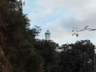  Lighthouse in the middle of the forest with a cloudy sky.