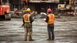 © G.Go - Two men in orange vests stand in a construction site