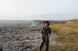 © SHOTPRIME STUDIO - Woman in a hat standing on top of hill with rock formation in background travel beauty in nature concept