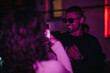 © qunica.com - A person in sunglasses and a stylish outfit enjoying a lively party atmosphere.