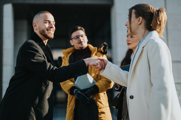 Wall Mural - Four individuals exchange ideas and interact enthusiastically while outdoors in a city environment, emphasizing team collaboration, networking, and professional growth.